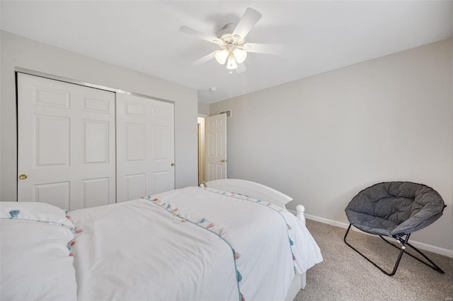 bedroom featuring light colored carpet, ceiling fan, and a closet