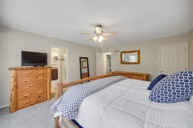 bedroom featuring light carpet, ceiling fan, and ensuite bathroom