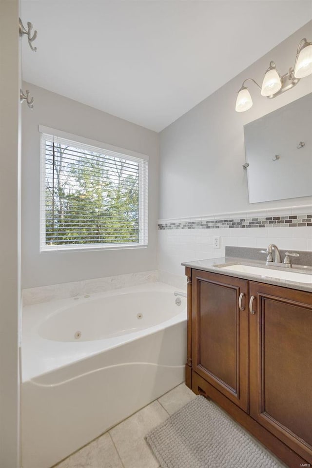 bathroom featuring tile patterned flooring, vanity, a tub, and tile walls