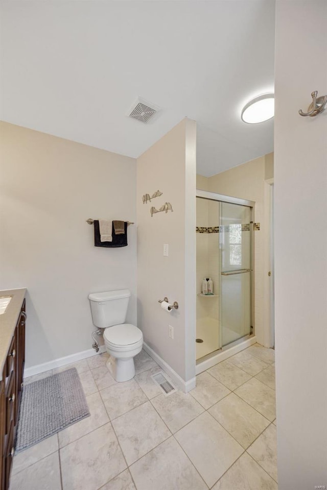 bathroom with tile patterned flooring, vanity, toilet, and walk in shower