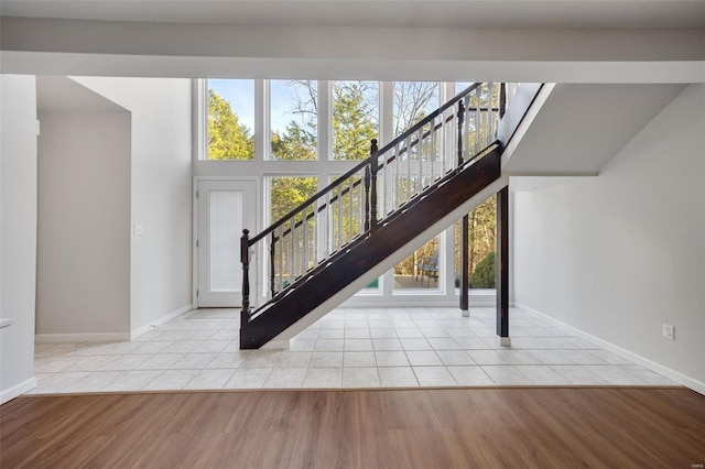 stairs with tile patterned flooring and a high ceiling