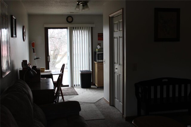 dining area with ceiling fan, light colored carpet, and a textured ceiling