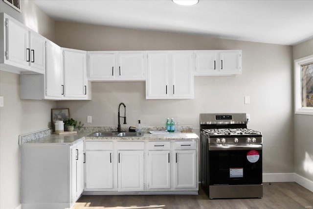 kitchen with a sink, visible vents, white cabinets, and stainless steel gas range