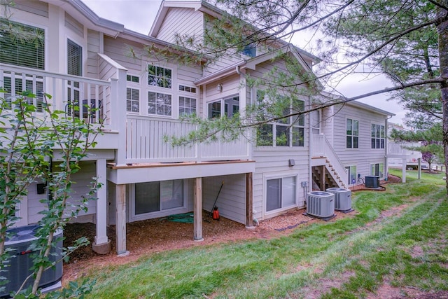 rear view of property featuring a yard and central air condition unit