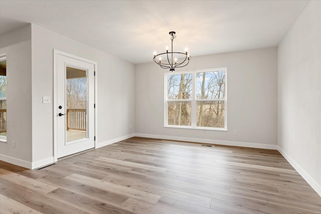 unfurnished dining area with light wood-style floors, visible vents, baseboards, and an inviting chandelier