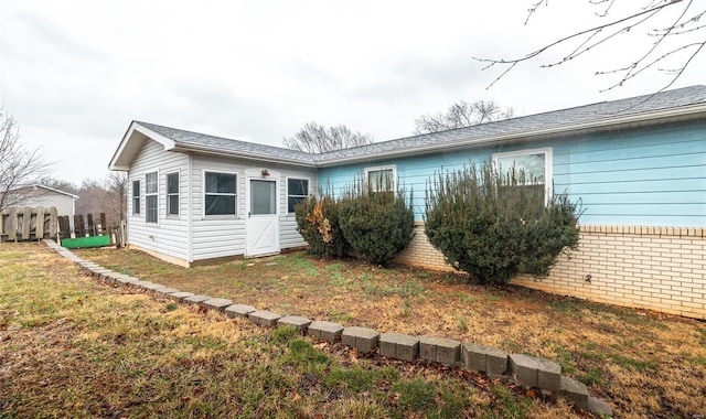 view of home's exterior featuring a yard, brick siding, and fence