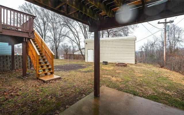 view of yard with fence, a patio, a wooden deck, and stairs