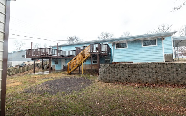 rear view of property with stairway, a wooden deck, and fence