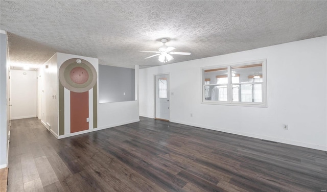 spare room with dark wood-style flooring, visible vents, ceiling fan, a textured ceiling, and baseboards