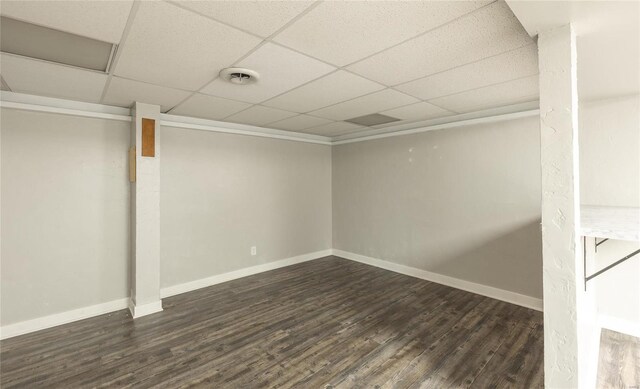 finished below grade area with dark wood-style floors, visible vents, baseboards, and a drop ceiling