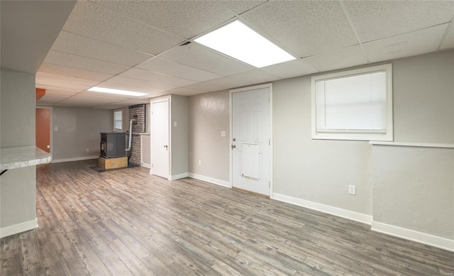 finished below grade area with a drop ceiling, wood finished floors, and baseboards