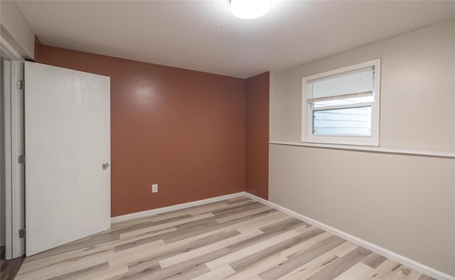 unfurnished room with light wood-style flooring and baseboards