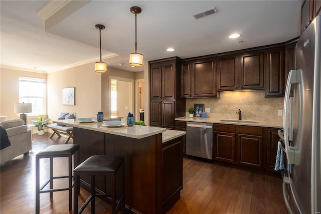 kitchen with stainless steel appliances, decorative light fixtures, sink, and dark brown cabinets