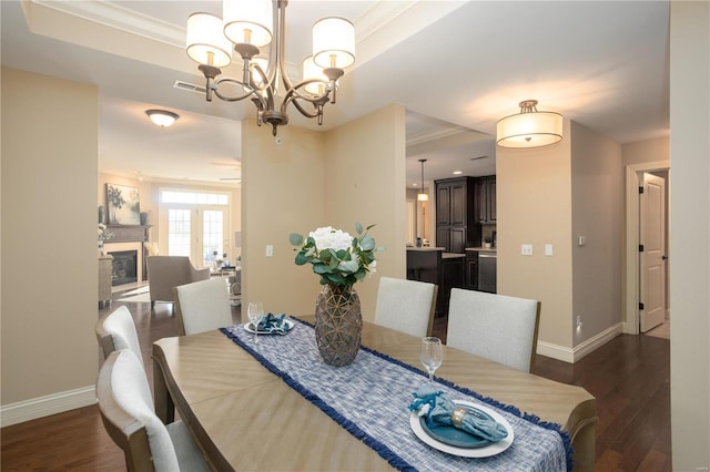 dining area with ornamental molding, a notable chandelier, and dark hardwood / wood-style flooring