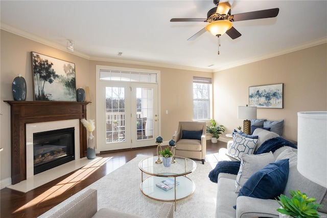 living room with crown molding, ceiling fan, and light wood-type flooring