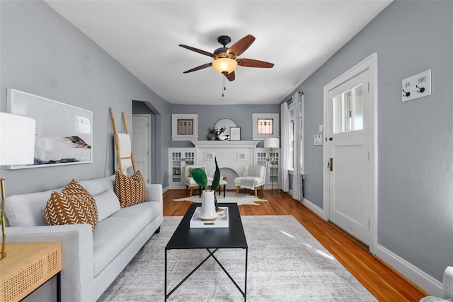 living room featuring wood-type flooring and ceiling fan