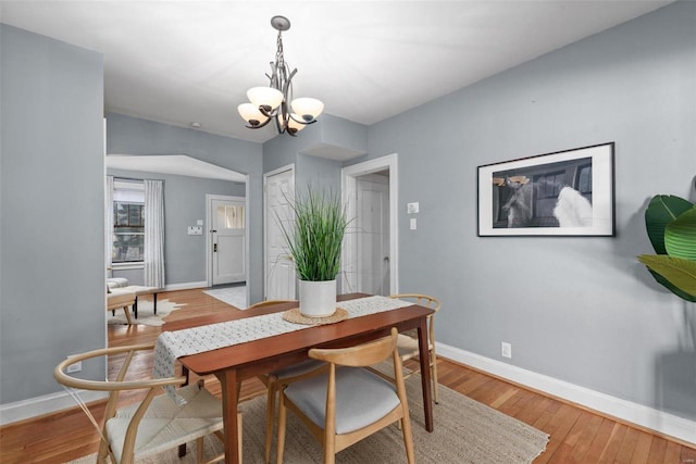 dining space featuring hardwood / wood-style flooring and a notable chandelier