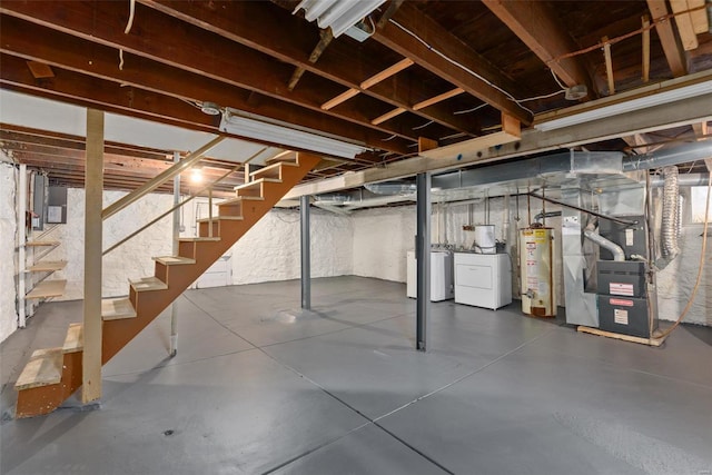 basement featuring water heater, washing machine and dryer, and heating unit