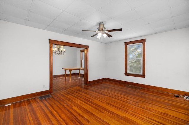 unfurnished room with visible vents, a paneled ceiling, wood finished floors, baseboards, and ceiling fan with notable chandelier