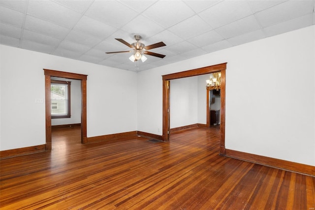 spare room featuring wood-type flooring, a ceiling fan, baseboards, and a drop ceiling