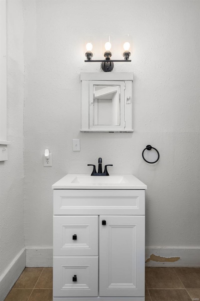 bathroom featuring tile patterned floors, baseboards, and vanity