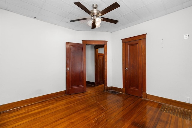 unfurnished bedroom featuring baseboards, a ceiling fan, and dark wood-style floors