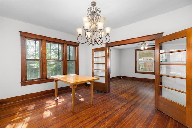 dining room with wood-type flooring, baseboards, ceiling fan with notable chandelier, and a wealth of natural light