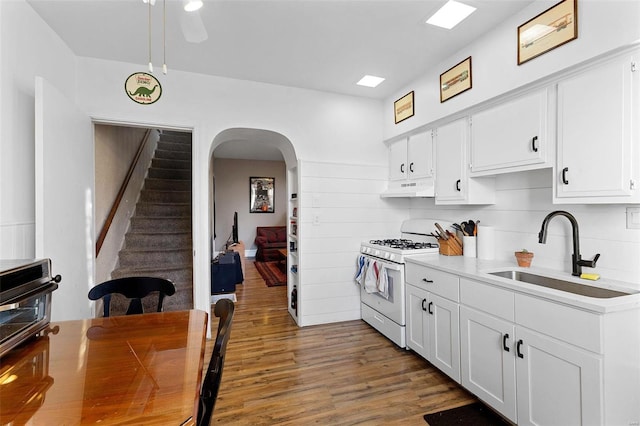 kitchen featuring white cabinetry, sink, and white gas stove