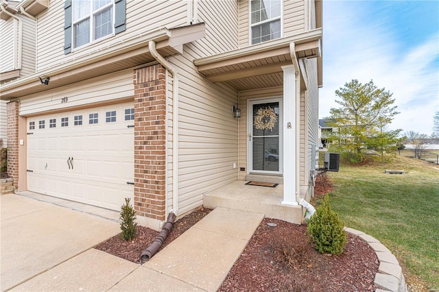 doorway to property with central AC, a garage, and a yard