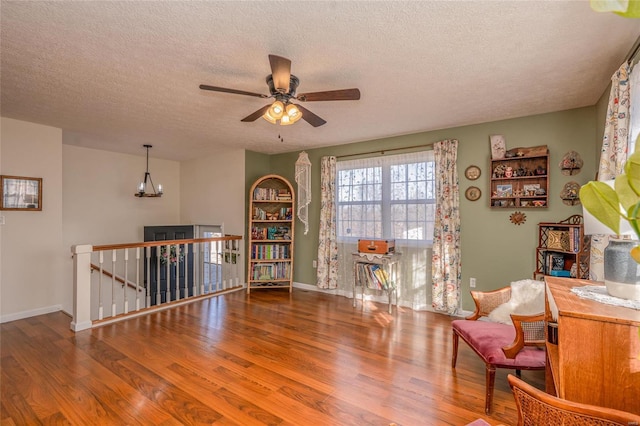 sitting room featuring ceiling fan, hardwood / wood-style floors, and a textured ceiling