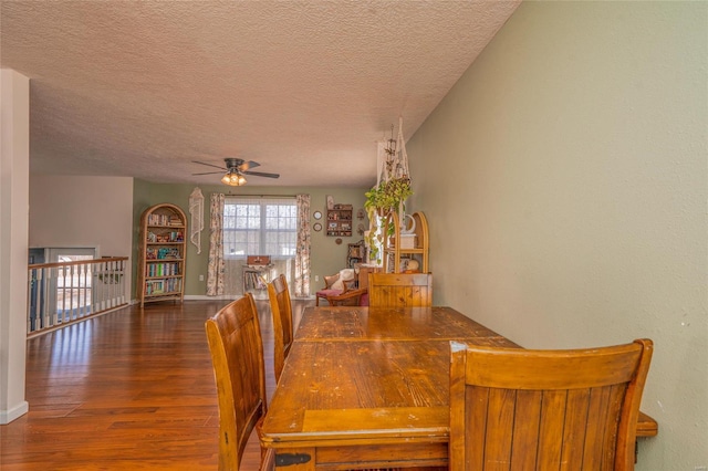 dining area featuring ceiling fan, dark wood-type flooring, and a textured ceiling