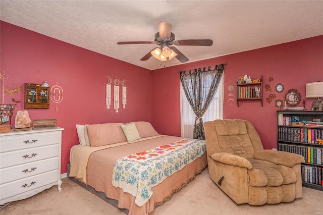 carpeted bedroom with ceiling fan and a textured ceiling