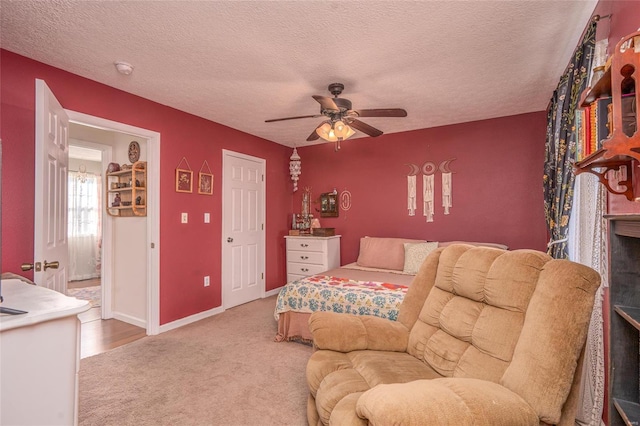 bedroom with ceiling fan, carpet flooring, and a textured ceiling