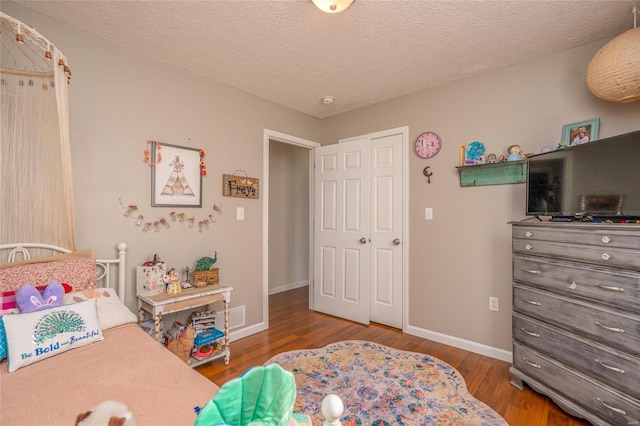 bedroom with wood-type flooring and a textured ceiling