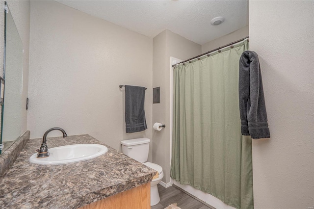 bathroom featuring toilet, a shower with curtain, a textured ceiling, vanity, and hardwood / wood-style floors