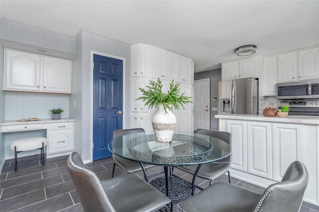 dining area with a textured ceiling and built in desk