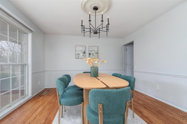 dining area with visible vents, baseboards, and wood finished floors