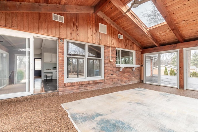 unfurnished sunroom with wood ceiling, vaulted ceiling with skylight, and visible vents