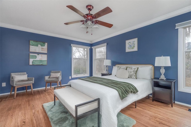 bedroom featuring ornamental molding, multiple windows, wood finished floors, and baseboards