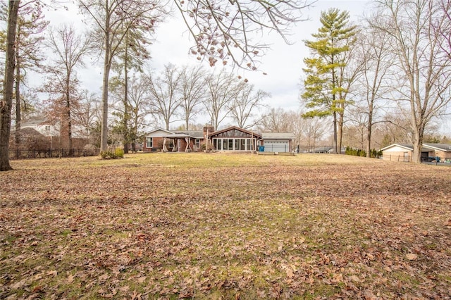 view of yard with a sunroom and fence