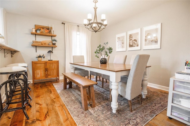 dining room with a notable chandelier and wood-type flooring