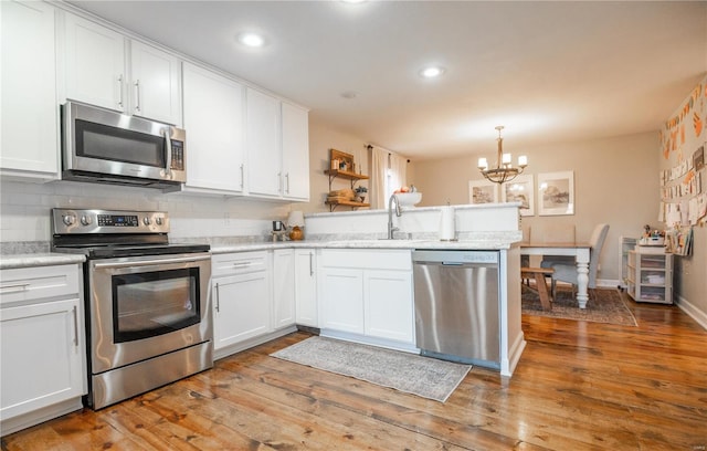 kitchen with appliances with stainless steel finishes, sink, and white cabinets