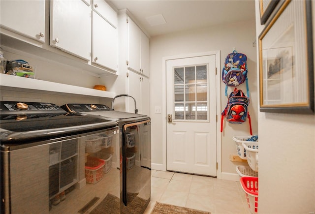 laundry room featuring separate washer and dryer, light tile patterned floors, and cabinets