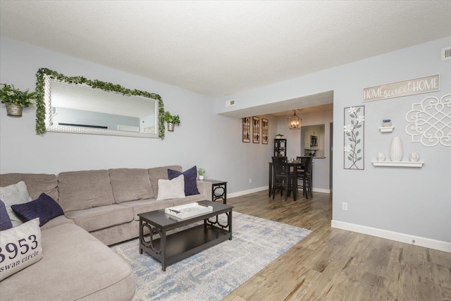 living room with wood-type flooring and a textured ceiling