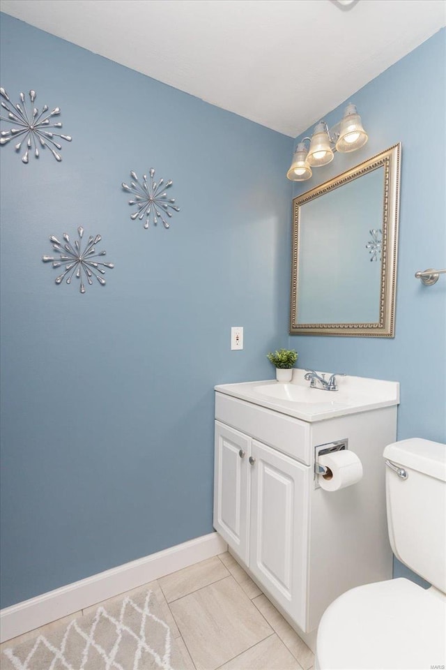 bathroom featuring tile patterned flooring, vanity, and toilet