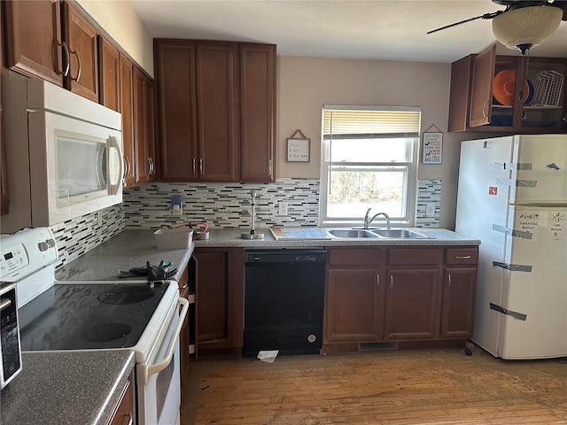 kitchen featuring sink, white appliances, hardwood / wood-style flooring, ceiling fan, and backsplash