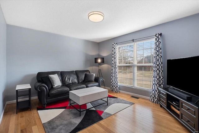 living room with light hardwood / wood-style floors and a textured ceiling