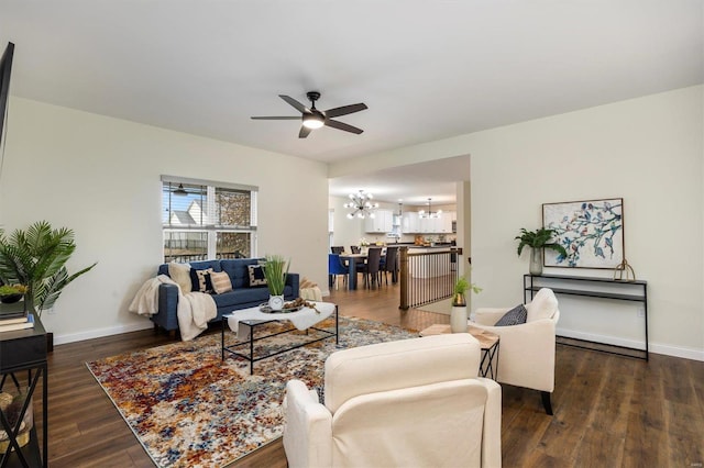 living room with dark hardwood / wood-style floors and ceiling fan with notable chandelier