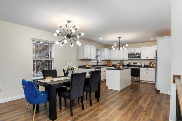 dining space with dark hardwood / wood-style flooring, sink, and a notable chandelier