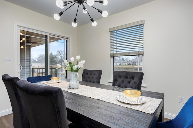 dining room with dark wood-type flooring and an inviting chandelier